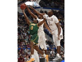 Florida State's Trent Forrest, back blocks a shot attempt by Vermont's Stef Smith, left, as Florida State's Raiquan Gray, right, defends, during the first half of a first round men's college basketball game in the NCAA tournament, Thursday, March 21, 2019, in Hartford, Conn.