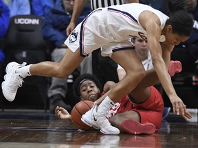 Connecticut's Megan Walker stumbles over Houston's Julia Blackshell-Fair, bottom, during the first half of an NCAA college basketball game, Saturday, March 2, 2019, in Storrs, Conn.