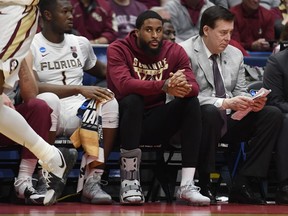 Florida State's Phil Cofer (0) sits on the bench with a boot on his right foot during the second half of a first round men's college basketball game against Vermont in the NCAA tournament, Thursday, March 21, 2019, in Hartford, Conn.