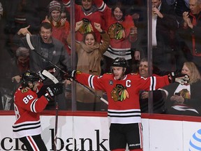 Chicago Blackhawks' Jonathan Toews right, celebrates with teammate Patrick Kane (88) after scoring a goal during the first period of an NHL hockey game against the Vancouver Canucks Monday, March 18, 2019, in Chicago.
