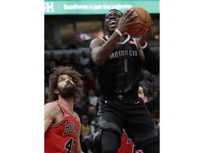 Detroit Pistons guard Reggie Jackson (1) drives to the basket against Chicago Bulls center Robin Lopez, left, and guard Ryan Arcidiacono during the first half of an NBA basketball game Friday, March 8, 2019, in Chicago.