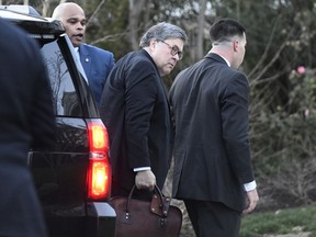 Attorney General William Barr carries his briefcase as he arrives at home in McLean, Va., on Friday evening, March 22, 2019. Special counsel Robert Mueller has concluded his investigation into Russian election interference and possible coordination with associates of President Donald Trump. The Justice Department says Mueller delivered his final report to Barr.