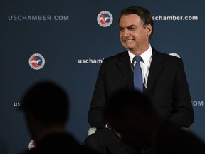 Brazilian President Jair Bolsonaro arrives on stage before speaking at the Chamber of Commerce in Washington, Monday, March 18, 2019.