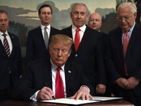 President Donald Trump, front, signs a proclamation in the Diplomatic Reception Room at the White House in Washington, Monday, March 25, 2019. Trump signed an official proclamation formally recognizing Israel's sovereignty over the Golan Heights. Others attending are, from left, Acting Defense Secretary Patrick Shanahan, White House adviser Jared Kushner, Israeli Prime Minister Benjamin Netanyahu, U.S. special envoy Jason Greenblatt, and U.S. Ambassador to Israel David Friedman.