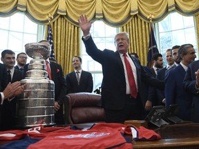 President Donald Trump, center, waves after hosting the 2018 Stanley Cup Champion Washington Capitals hockey team in the Oval Office of the White House in Washington, Monday, March 25, 2019.