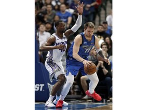 Sacramento Kings forward Harrison Barnes (40) defends as Dallas Mavericks forward Luka Doncic (77) works to the basket in the first half of an NBA basketball game in Dallas, Tuesday, March 26, 2019.
