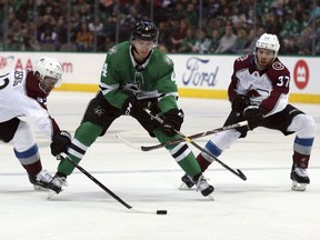 Colorado Avalanche left wing Gabriel Landeskog (92) and left wing J.T. Compher (37) try to get the puck from Dallas Stars defenseman Miro Heiskanen (4) in the first period in an NHL hockey game Thursday, March 7, 2019, in Dallas.