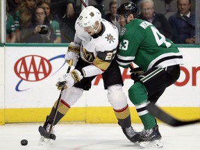 Vegas Golden Knights defenseman Shea Theodore (27) and Dallas Stars right wing Valeri Nichushkin (43) work to control a puck in the first period of an NHL hockey game in Dallas, Friday, March 15, 2019.