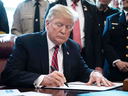 U.S. President Donald Trump signs the first veto of his presidency, overriding a congressional resolution to secure emergency funds to build a wall on the U.S.-Mexico border, March 15, 2019.