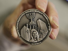 This Wednesday, March 13, 2019. photo shows a coin emblazoned with the face of Nikki Haley, President Donald Trump's former ambassador to the United Nations, to commemorate her defense of Israel in the United Nations, in Jerusalem. The Sanhedrin, a Jewish group that says it aims to restore the Jewish Temple in Jerusalem, is one of three groups behind the coin.