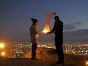 A couple lights a lantern during a celebration, known as "Chaharshanbe Souri," or Wednesday Feast, marking the eve of the last Wednesday of the solar Persian year, Tuesday, March 19, 2019, in Tehran, Iran. Iran's many woes briefly went up in smoke on Tuesday as Iranians observed a nearly 4,000-year-old Persian tradition known as the Festival of Fire.