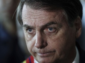 Brazil's President Jair Bolsonaro listens to a reporter's question at the end of a military ceremony where he was awarded the Order of Military Judicial Merit, in Brasilia, Brazil, Thursday, March 28, 2019. Bolsonaro, a former army captain who waxes nostalgic for the 1964-1985 dictatorship, on Monday asked Brazil's Defense Ministry to organize "due commemorations" to mark the upcoming March 31st anniversary of Brazil's 1964 military coup.