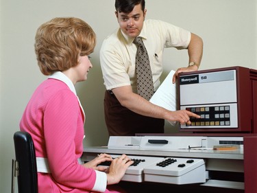 A woman does data entry while sporting a very bold colour in the '70s.
