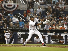 Miami Marlins' Starlin Castro (13) hits a single in the fourth inning during a baseball game against the Colorado Rockies, Thursday, March 28, 2019, in Miami.