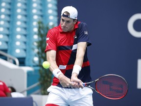 John Isner returns a volley to Albert Ramos-Vinglas, of Spain, during the Miami Open tennis tournament, Sunday, March 24, 2019, in Miami Gardens, Fla.