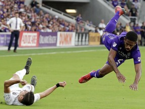 D.C. United's Joseph Mora, left, collides with Orlando City's Ruan, right, while going after the ball during the first half of an MLS soccer match Sunday, March 31, 2019, in Orlando, Fla. Mora was injured in the play and left the match.