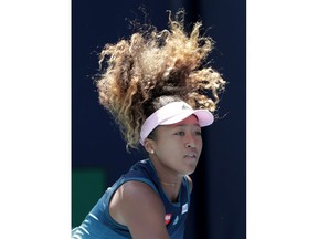 Naomi Osaka, of Japan, follows through on a serve to Yanina Wickmayer, of Belgium, during the Miami Open tennis tournament, Friday, March 22, 2019, in Miami Gardens, Fla.