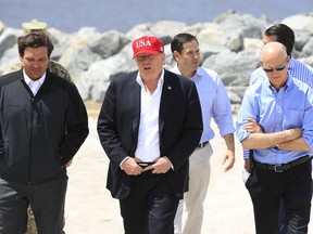 President Donald Trump walks with, from left, Florida Gov. Ron DeSantis, Sen. Marco Rubio, R-Fla., and Sen. Rick Scott, R-Fla., during a visit to Lake Okeechobee and Herbert Hoover Dike at Canal Point, Fla., Friday, March 29, 2019.