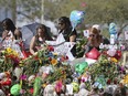 In this Feb. 25, 2018 file photo, mourners bring flowers as they pay tribute at a memorial for the victims of the shooting at Marjory Stoneman Douglas High School, in Parkland, Fla. The community of Parkland, Florida, is focusing on suicide prevention programs after two survivors of the Florida high school massacre there killed themselves this month.