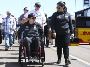 Robert Wickens, left, leaves the pit area at the IndyCar Grand Prix of St. Petersburg auto race in St. Petersburg, Fla., Friday, March 8, 2019. Wickens returned to a race track for the first time since he suffered a major spinal cord injury in a crash six months ago.
