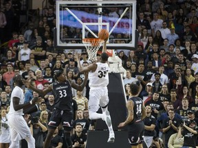Central Florida forward Collin Smith (35) lays up the ball against Cincinnati center Nysier Brooks (33) and guard Jarron Cumberland (34) during the first half of an NCAA college basketball game, Thursday, March 7, 2019, in Orlando, Fla.