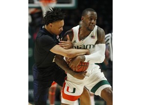 Pittsburgh guard Trey McGowens, left, and Miami guard Zach Johnson, right, battle for a ball during the first half of an NCAA college basketball game, Tuesday, March 5, 2019, in Coral Gables, Fla.