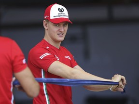 FILE - In this Friday, Nov. 30, 2018 file photo, Mick Schumacher warms up ahead of a test drive with his new formula 2 Prema racing car at the Yas Marina Circuit in Abu Dhabi, United Arab Emirates. Mick Schumacher will move closer toward emulating his father when he drives a Ferrari Formula One car in an official test next week. Ferrari says the 20-year-old Mick Schumacher will test April 2 in Bahrain. The German, who is racing in Formula Two this year with the Prema team and is a Ferrari Driver Academy member, will drive on both days of the testing session. On April 3, he will be at the wheel of an Alfa Romeo on the Sakhir circuit. Schumacher's father Michael won seven F1 titles, five of those with Ferrari from 2000-04.