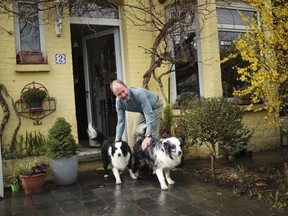 In this photo taken on Wednesday, March 13, 2019, British lobbyist Brian O'Riordan poses with his dogs in his house in Rixensart, outside Brussels. Britons in Brussels are fretting about how their country's looming departure will affect their daily lives. Growing numbers are taking Belgian nationality as a way of ensuring they can still live, work and travel freely in Europe after Brexit.