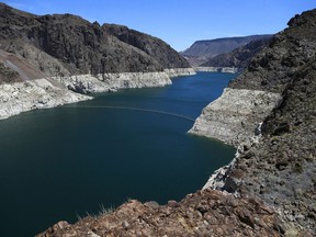 FILE - This May 31, 2018 file photo shows the reduced water level of Lake Mead behind Hoover Dam in Arizona. Several states that rely on a major Western river are pushing for federal legislation to implement a plan to keep key reservoirs from shrinking amid a prolonged drought. The Colorado River serves 40 million people in Arizona, California, Colorado, Nevada, New Mexico, Utah and Wyoming. Representatives from those states are meeting Tuesday, March 19, 2019, to sign a letter to Congress asking for support for so-called drought contingency plans.
