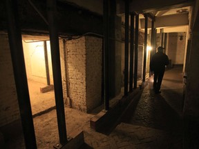 File - In this July 7, 2011, file photo, Jim Breeden of the Golden Gate National Parks Conservancy, walks through the dungeons below the main cell house during a night tour on Alcatraz Island in San Francisco. Archaeologists have confirmed a long-time suspicion of historians: the famed Alcatraz prison was built over a Civil War-era military fortification. SFGate reports researchers have found a series of buildings and tunnels under the prison yard of Alcatraz Federal Penitentiary, which once held Al Capone.