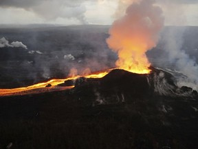 FILE - In this July 14, 2018 photo provided by the U.S. Geological Survey, lava from Kilauea volcano erupts in the Leilani Estates neighborhood near Pahoa, Hawaii. Scientists have downgraded the alert level for Hawaii's Kilauea volcano in response to reduced activity, saying the next eruption is likely a few years away. The U.S. Geological Survey's Hawaiian Volcano Observatory announced Tuesday, March 26, 2019, that the alert level for the Big Island volcano has been lowered from "advisory" to "normal," the Hawaii Tribune-Herald reported.