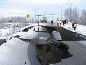 FILE - In this Nov. 30, 2018, file photo, workers inspect an off-ramp that collapsed during a morning earthquake in Anchorage, Alaska. Seismologists announced Friday, March 8, 2019, the magnitude of Alaska's powerful Nov. 30 earthquake has been revised to 7.1 from the earlier magnitude 7.0. Alaska Earthquake Center officials say in a release that the change comes after quake data was reviewed by multiple agency and academic groups.