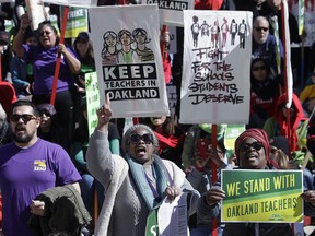 FILE - In this Thursday, Feb. 21, 2019, file photo, teachers, students and supporters rally at Frank Ogawa Plaza in front of City Hall in Oakland, Calif. School leaders and teachers in Oakland have reached a tentative deal to end a week-long strike. The school district said Friday, March 1, 2019, that teachers will receive an 11 percent salary increase plus a one-time 3 percent bonus. Oakland's 3,000 teachers walked off the job Feb. 21 to demand higher pay, smaller class sizes and more school resources.