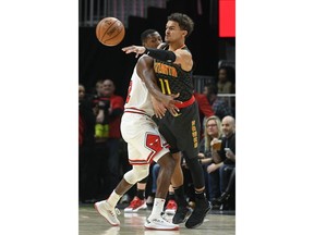 Atlanta Hawks guard Trae Young (11) makes a pass as Chicago Bulls guard Kris Dunn defends during the first half of an NBA basketball game Friday, March 1, 2019, in Atlanta.