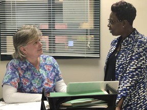 In this Feb. 28, 2019 photo, Linda Espinosa, left, a school nurse at Freedom Middle School in the Atlanta metro-area, speaks to school counselor, Tijuana Williams, about schoolgirls coming in to her office to get sanitary pads, in Atlanta. Georgia's legislature is joining a nationwide effort to provide menstrual products for public school students in need.