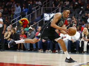 Milwaukee Bucks forward Bonzie Colson (50) saves the ball in the first half of an NBA basketball game against the Atlanta Hawks on Sunday, March 31, 2019, in Atlanta.