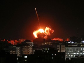 A ball of fire lights the sky above a building believed to house the offices of Hamas chief in Gaza, Ismail Haniyeh, during Israeli strikes on the Gaza City, on March 25, 2019.