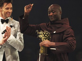 Kenyan teacher Peter Tabichi, right, reacts near actor Hugh Jackman, after winning the $1 million Global Teacher Prize in Dubai.