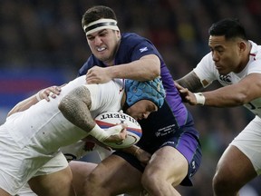England's Jack Nowell, left, is tackled by Scotland's Stuart McInally, center, during the Six Nations rugby union international between England and Scotland at Twickenham stadium in London, Saturday, March 16, 2019.