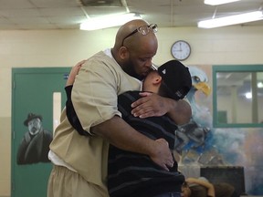 In this undated photo provided by filmmaker Denali Tiller, Tre Janson, right, and his father greet each other on Saturday visiting hours at John J. Moran Medium Security Prison in Cranston, R.I. Tiller's four-year-long project "Tre Maison Dasan," documenting the lives of children with parents in prison, is set to air Monday, April 1, 2019, on most PBS stations as part of the series "Independent Lens."