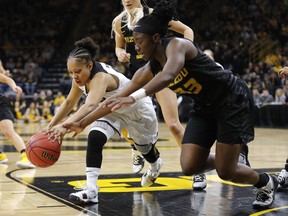 Iowa guard Tania Davis, left, fights for a loose ball with Missouri guard Amber Smith during a second round women's college basketball game in the NCAA Tournament, Sunday, March 24, 2019, in Iowa City, Iowa.