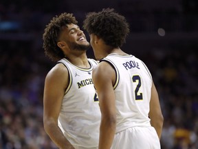 Michigan forward Isaiah Livers, left, celebrates with teammate Jordan Poole after making a basket during a second round men's college basketball game against Florida in the NCAA Tournament, Saturday, March 23, 2019, in Des Moines, Iowa.