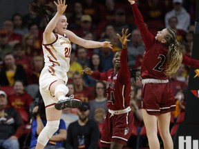 Iowa State guard Bridget Carleton, left, leaps to pass the ball back past New Mexico State guard Brooke Salas, right, during the first half of a first-round game in the NCAA women's college basketball tournament, Saturday, March 23, 2019, in Ames, Iowa.