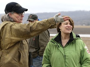 Pacific Junction, Iowa, resident Fran Karr, left, points out to Democratic presidential candidate Sen. Amy Klobuchar, D-Minn., the location of her flooded home, during a stop to the recently flooded town of Pacific Junction, Iowa, Friday, March 29, 2019. Jason Karr, Frans's husband stands rear center.