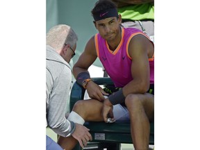 Rafael Nadal, of Spain, gets his knee wrapped by a trainer during his match against Karen Khachanov, of Russia, at the BNP Paribas Open tennis tournament Friday, March 15, 2019, in Indian Wells, Calif.