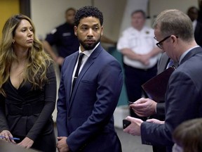 FILE - This March 14, 2019 file photo, actor Jussie Smollet, center, looks at attorney Ron Safer as he stands with his lead attorney Tina Glandian in Cook County Circuit Court in Chicago. Attorneys for Smollett said Tuesday, March 26, that charges alleging he lied to police about a racist and homophobic attack have been dropped. Smollett was indicted on 16 felony counts related to making a false report that he was attacked by two men.
