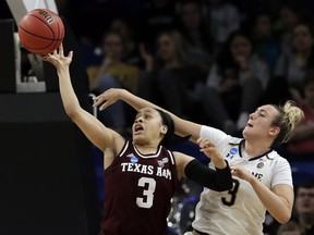 Texas A&M's Chennedy Carter, left, and Notre Dame's Marina Mabrey battle for a loose ball during the first half of a regional semifinal game in the NCAA women's college basketball tournament, Saturday, March 30, 2019, in Chicago.