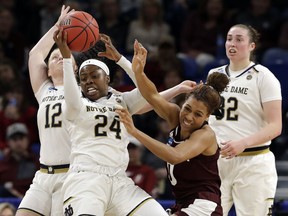 Notre Dame's Arike Ogunbowale (24) grabs a rebound against Texas A&M's Aja Ellison (0) during the second half of a regional semifinal game in the NCAA women's college basketball tournament, Saturday, March 30, 2019, in Chicago.