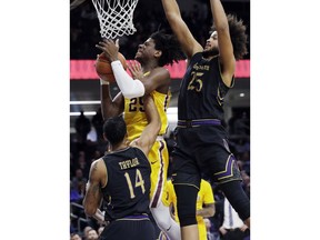 Minnesota center Daniel Oturu (25) pulls in a rebound between Northwestern guard Ryan Taylor, left, and center Barret Benson during the first half of an NCAA college basketball game Thursday, Feb. 28, 2019, in Evanston, Ill.