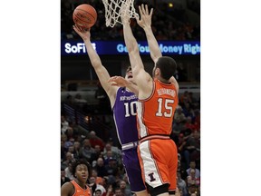 Northwestern forward Miller Kopp, left, shoots against Illinois forward Giorgi Bezhanishvili during the first half of an NCAA college basketball game in the first round of the Big Ten Conference tournament in Chicago, Wednesday, March 13, 2019.